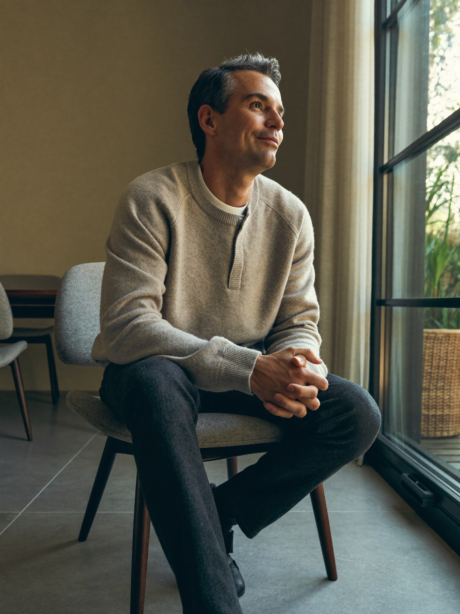 A composed professional man resting comfortably at home during a light recovery, fully dressed